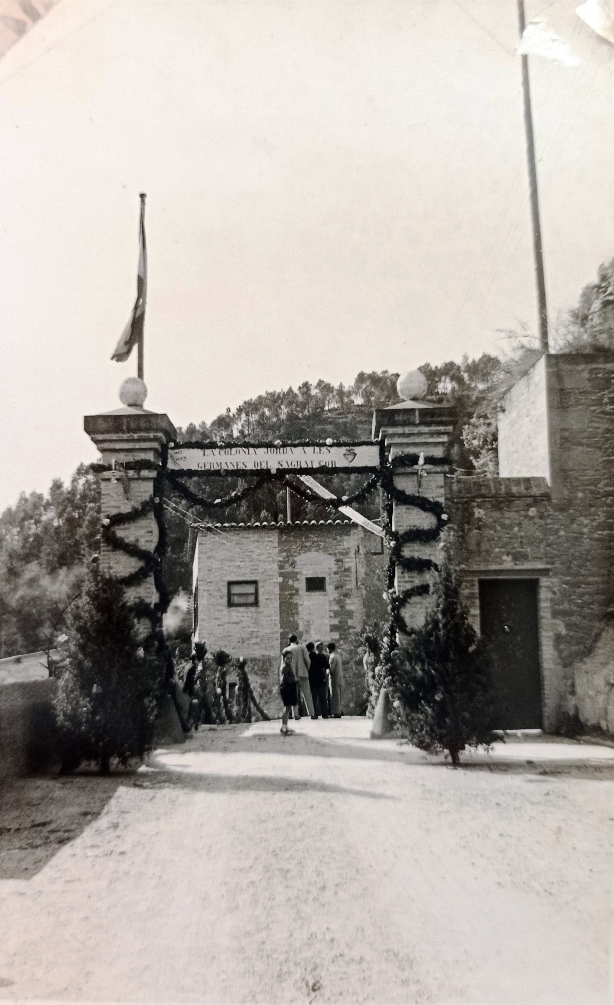 imatge Entrada de la colònia Jorba amb decorat per la festa de commemoració de les noces d'or de la fundació de la Congregació del Sagrat Cor de Jesús en aquesta colònia, 1953, Calders. Arxiu Municipal de Calders.