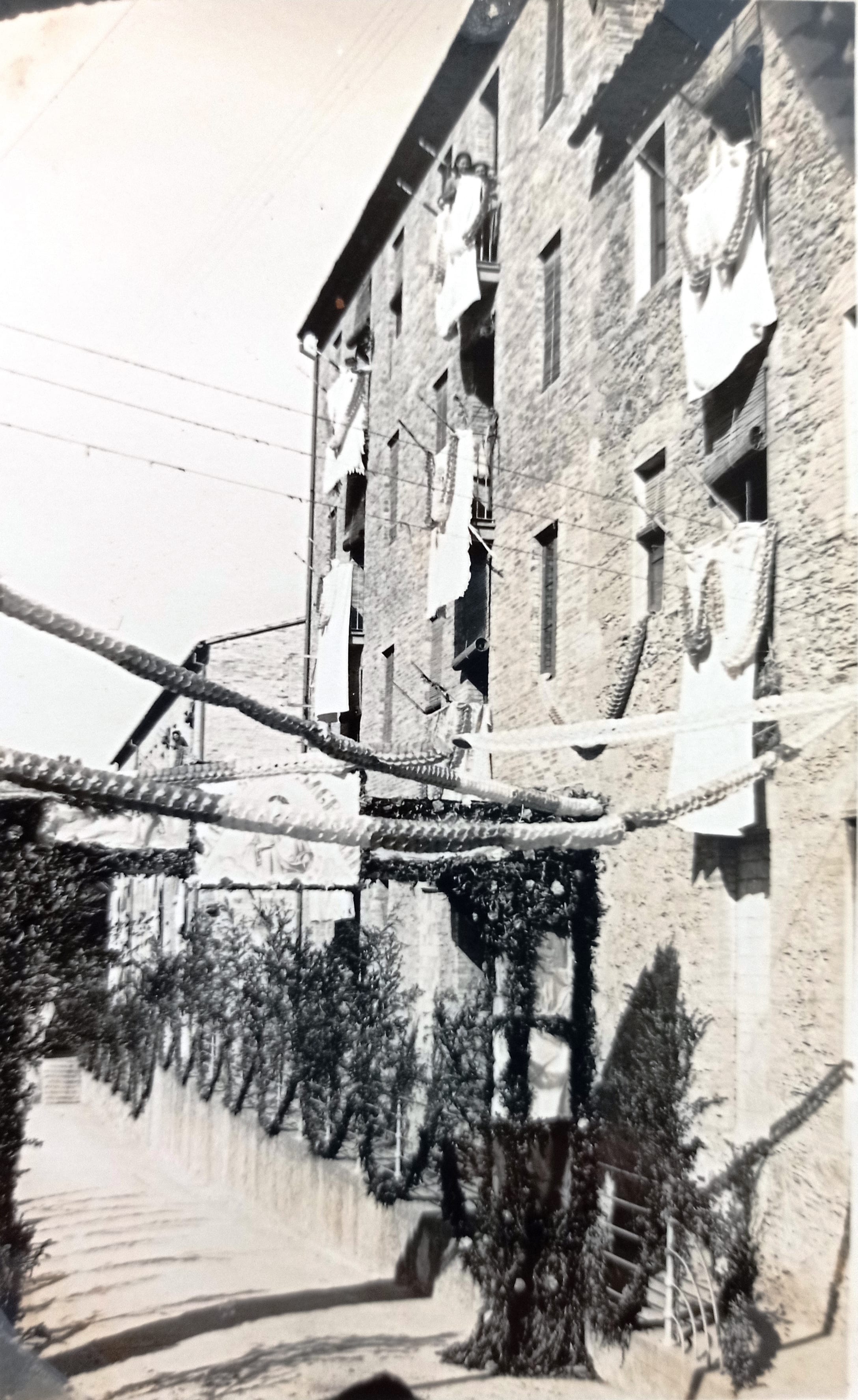 imatge Carrer de la colònia Jorba decorat per la festa de commemoració de les noces d'or de la fundació de la Congregació del Sagrat Cor de Jesús en aquesta colònia, 1953, Calders. Arxiu Municipal de Calders.
