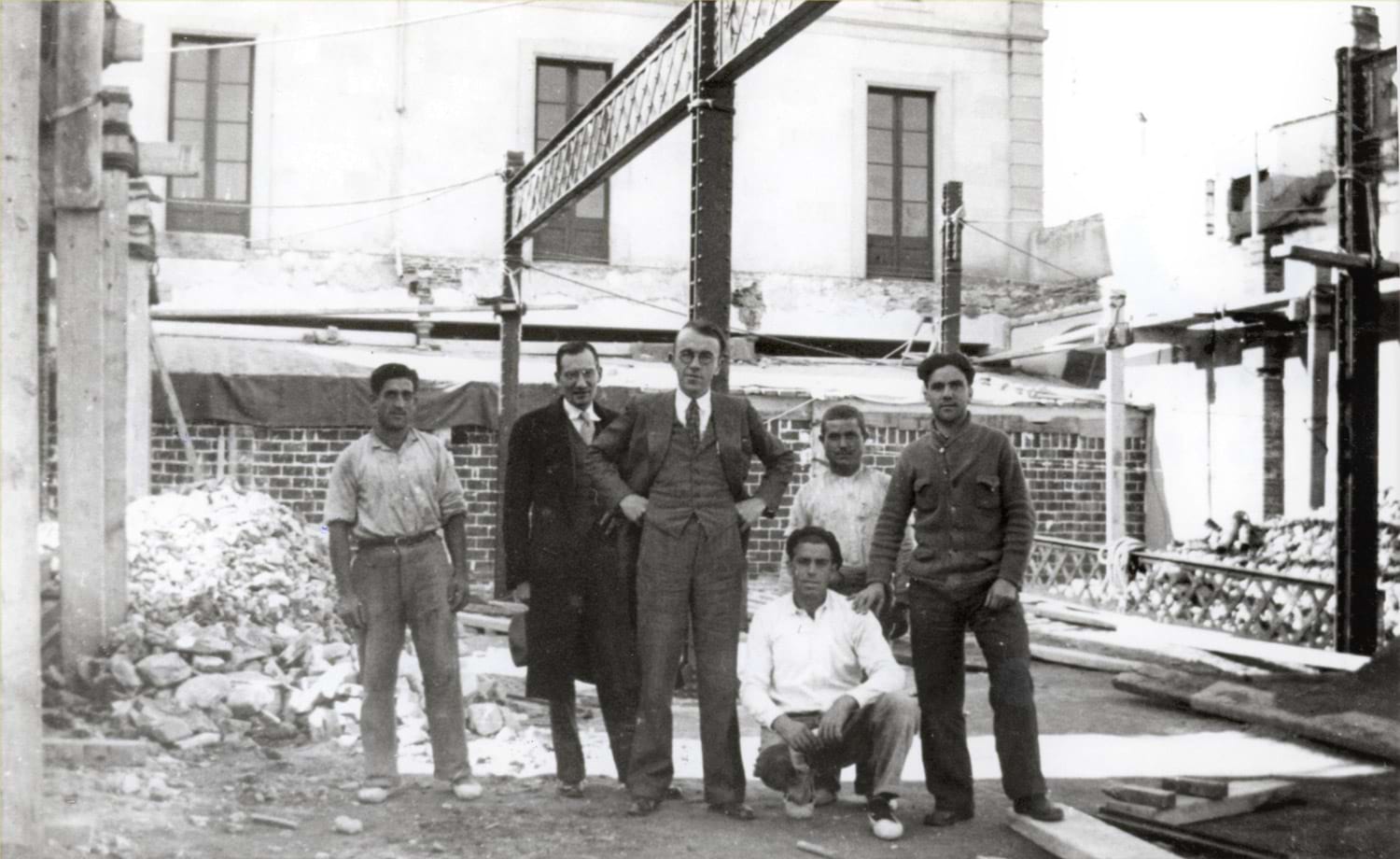 Obres d’ampliació i remodelació de l’Escola de Teixits de Punt. El director, Paul-Émile Muller, al centre dempeus, 5 de desembre 1934. Autoria desconeguda. Fons: Diputació de Barcelona (CAT AGDB R. 2747)